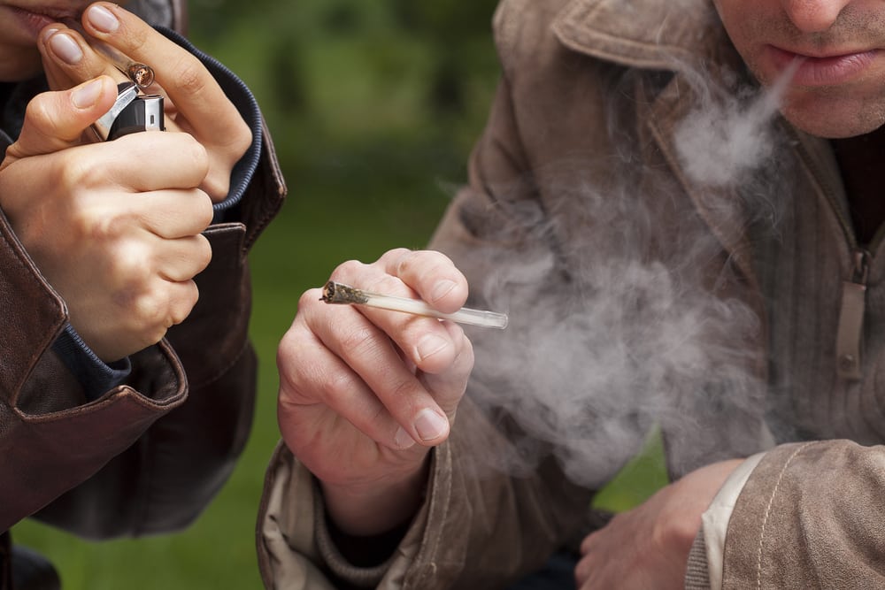 People smoking maijuana from a one hitter